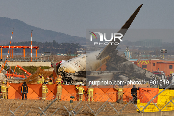 Fire authorities search for the missing and recover the deceased at the site of an accident near Muan International Airport in Jeollanam-do,...