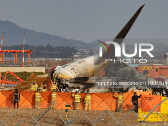 Fire authorities search for the missing and recover the deceased at the site of an accident near Muan International Airport in Jeollanam-do,...