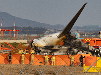 Fire authorities search for the missing and recover the deceased at the site of an accident near Muan International Airport in Jeollanam-do,...