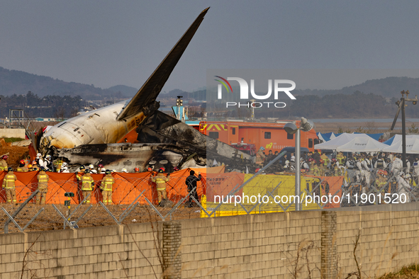 Fire authorities search for the missing and recover the deceased at the site of an accident near Muan International Airport in Jeollanam-do,...