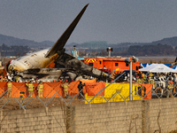 Fire authorities search for the missing and recover the deceased at the site of an accident near Muan International Airport in Jeollanam-do,...