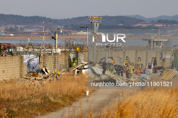 Fire authorities search for the missing and recover the deceased at the site of an accident near Muan International Airport in Jeollanam-do,...