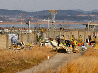 Fire authorities search for the missing and recover the deceased at the site of an accident near Muan International Airport in Jeollanam-do,...