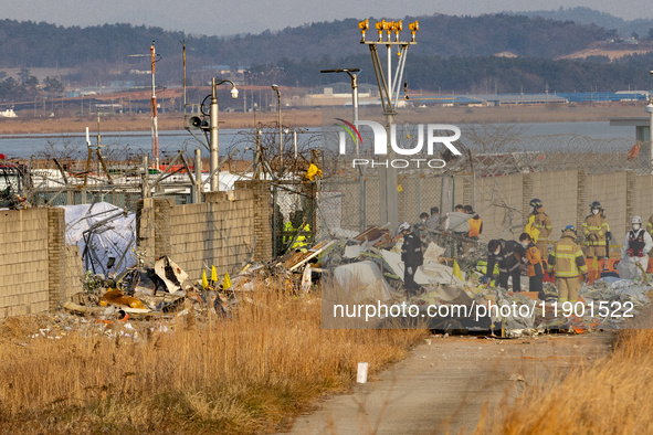 Fire authorities search for the missing and recover the deceased at the site of an accident near Muan International Airport in Jeollanam-do,...