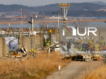 Fire authorities search for the missing and recover the deceased at the site of an accident near Muan International Airport in Jeollanam-do,...