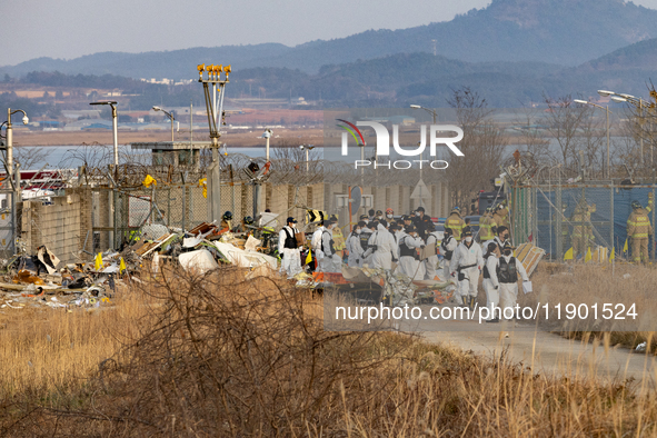 Fire authorities search for the missing and recover the deceased at the site of an accident near Muan International Airport in Jeollanam-do,...