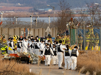 Fire authorities search for the missing and recover the deceased at the site of an accident near Muan International Airport in Jeollanam-do,...