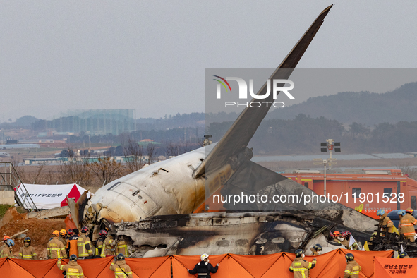 Fire authorities search for the missing and recover the deceased at the site of an accident near Muan International Airport in Jeollanam-do,...