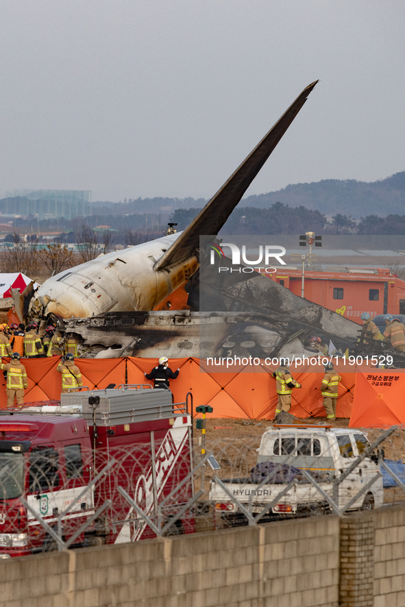 Fire authorities search for the missing and recover the deceased at the site of an accident near Muan International Airport in Jeollanam-do,...