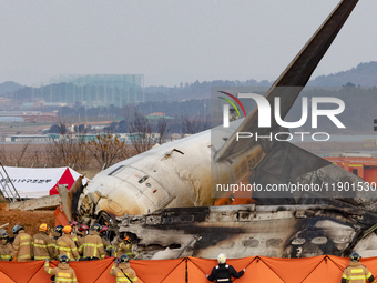 Fire authorities search for the missing and recover the deceased at the site of an accident near Muan International Airport in Jeollanam-do,...