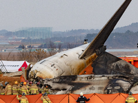 Fire authorities search for the missing and recover the deceased at the site of an accident near Muan International Airport in Jeollanam-do,...