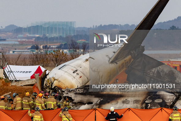 Fire authorities search for the missing and recover the deceased at the site of an accident near Muan International Airport in Jeollanam-do,...