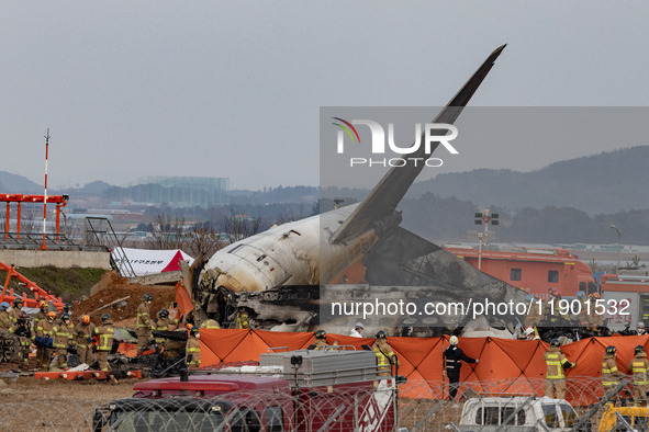 Fire authorities search for the missing and recover the deceased at the site of an accident near Muan International Airport in Jeollanam-do,...