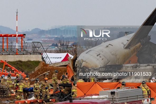 Fire authorities search for the missing and recover the deceased at the site of an accident near Muan International Airport in Jeollanam-do,...