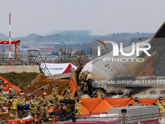 Fire authorities search for the missing and recover the deceased at the site of an accident near Muan International Airport in Jeollanam-do,...