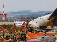 Fire authorities search for the missing and recover the deceased at the site of an accident near Muan International Airport in Jeollanam-do,...