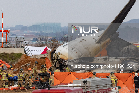 Fire authorities search for the missing and recover the deceased at the site of an accident near Muan International Airport in Jeollanam-do,...