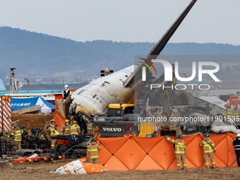 Fire authorities search for the missing and recover the deceased at the site of an accident near Muan International Airport in Jeollanam-do,...