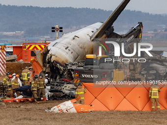 Fire authorities search for the missing and recover the deceased at the site of an accident near Muan International Airport in Jeollanam-do,...