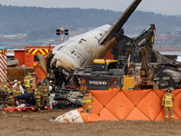 Fire authorities search for the missing and recover the deceased at the site of an accident near Muan International Airport in Jeollanam-do,...