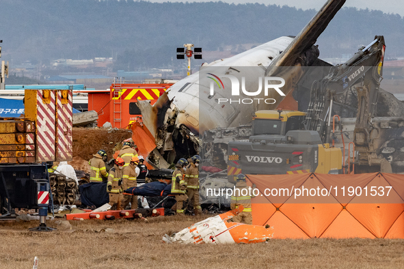 Fire authorities search for the missing and recover the deceased at the site of an accident near Muan International Airport in Jeollanam-do,...