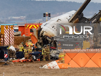 Fire authorities search for the missing and recover the deceased at the site of an accident near Muan International Airport in Jeollanam-do,...