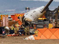 Fire authorities search for the missing and recover the deceased at the site of an accident near Muan International Airport in Jeollanam-do,...