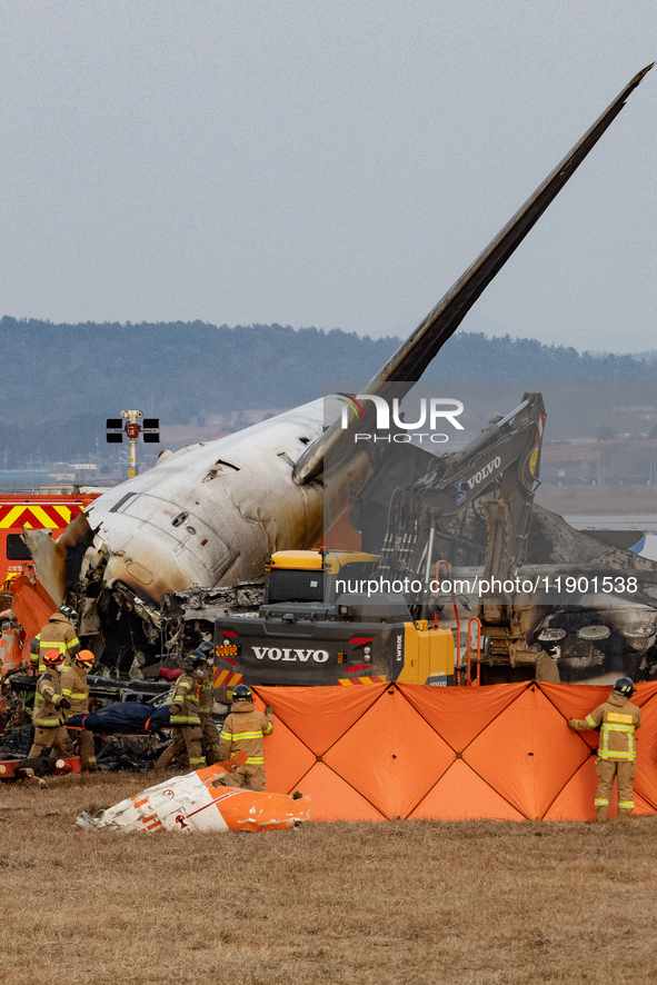 Fire authorities search for the missing and recover the deceased at the site of an accident near Muan International Airport in Jeollanam-do,...