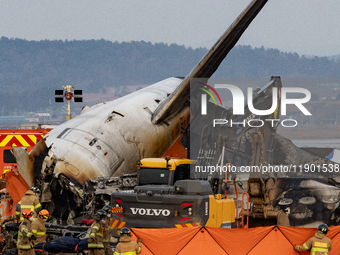 Fire authorities search for the missing and recover the deceased at the site of an accident near Muan International Airport in Jeollanam-do,...