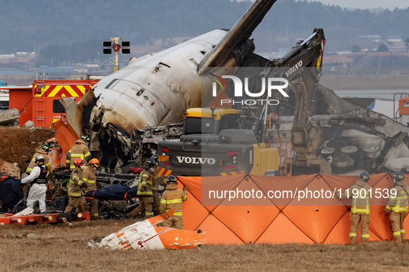 Fire authorities search for the missing and recover the deceased at the site of an accident near Muan International Airport in Jeollanam-do,...