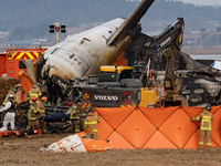 Fire authorities search for the missing and recover the deceased at the site of an accident near Muan International Airport in Jeollanam-do,...