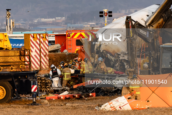 Fire authorities search for the missing and recover the deceased at the site of an accident near Muan International Airport in Jeollanam-do,...