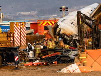 Fire authorities search for the missing and recover the deceased at the site of an accident near Muan International Airport in Jeollanam-do,...