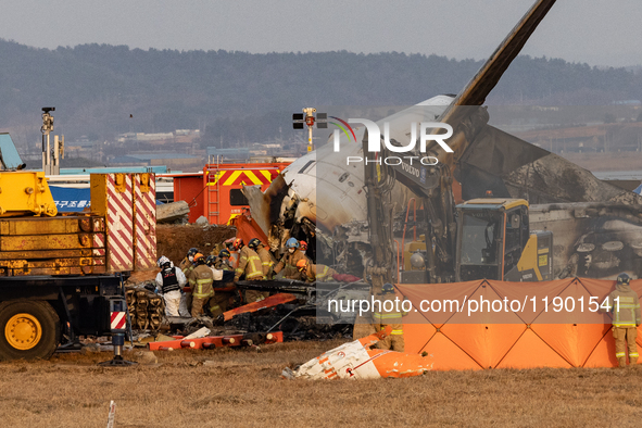 Fire authorities search for the missing and recover the deceased at the site of an accident near Muan International Airport in Jeollanam-do,...