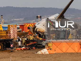 Fire authorities search for the missing and recover the deceased at the site of an accident near Muan International Airport in Jeollanam-do,...