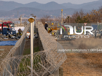 Fire authorities search for the missing and recover the deceased at the site of an accident near Muan International Airport in Jeollanam-do,...