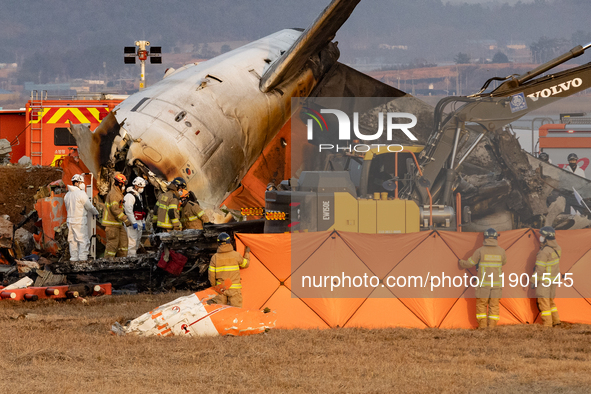 Fire authorities search for the missing and recover the deceased at the site of an accident near Muan International Airport in Jeollanam-do,...