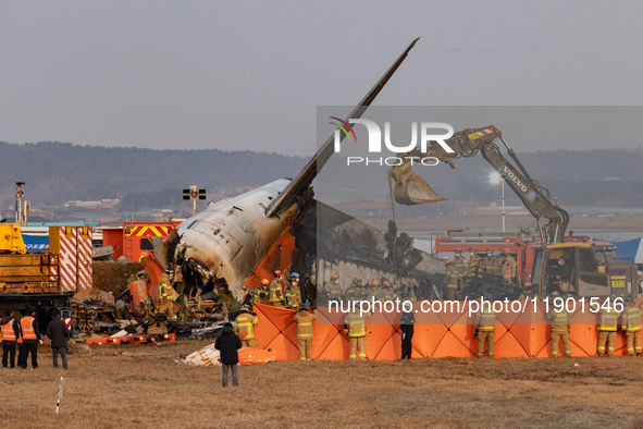 Fire authorities search for the missing and recover the deceased at the site of an accident near Muan International Airport in Jeollanam-do,...