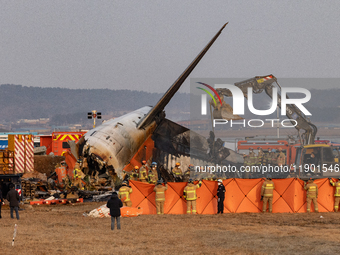 Fire authorities search for the missing and recover the deceased at the site of an accident near Muan International Airport in Jeollanam-do,...