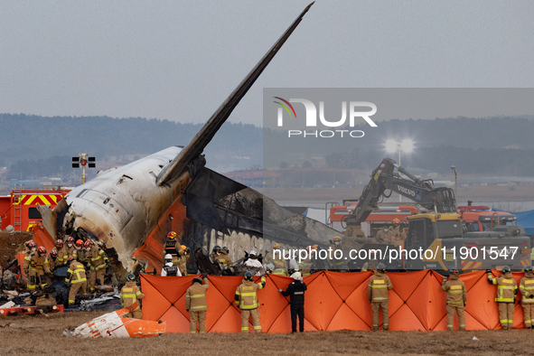 Fire authorities search for the missing and recover the deceased at the site of an accident near Muan International Airport in Jeollanam-do,...