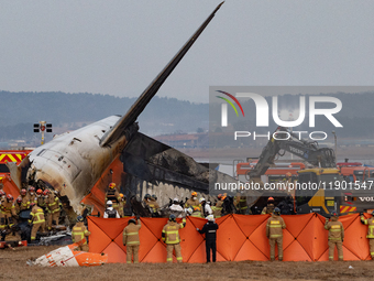 Fire authorities search for the missing and recover the deceased at the site of an accident near Muan International Airport in Jeollanam-do,...