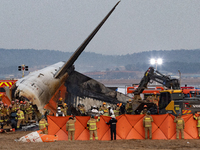 Fire authorities search for the missing and recover the deceased at the site of an accident near Muan International Airport in Jeollanam-do,...