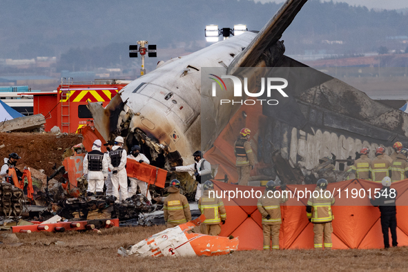 Fire authorities search for the missing and recover the deceased at the site of an accident near Muan International Airport in Jeollanam-do,...