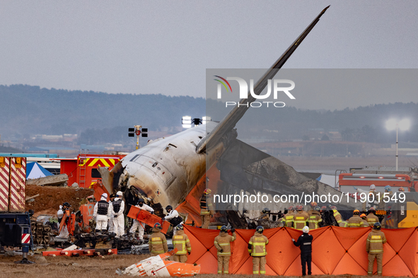 Fire authorities search for the missing and recover the deceased at the site of an accident near Muan International Airport in Jeollanam-do,...