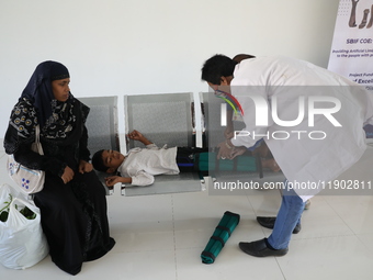 A doctor fits gaiters on a boy's limbs inside the Rehabilitation & Research Centre, a unit of Mahavir Seva Sadan, in Arambag on the outskirt...