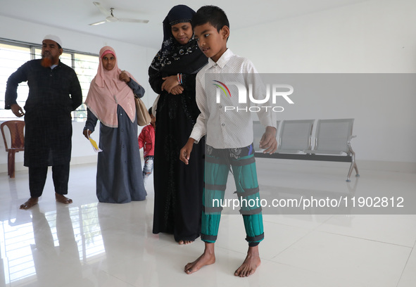 A boy tries to walk after being fitted with gaiters on his limbs inside the Rehabilitation & Research Centre, a unit of Mahavir Seva Sadan,...