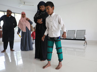 A boy tries to walk after being fitted with gaiters on his limbs inside the Rehabilitation & Research Centre, a unit of Mahavir Seva Sadan,...