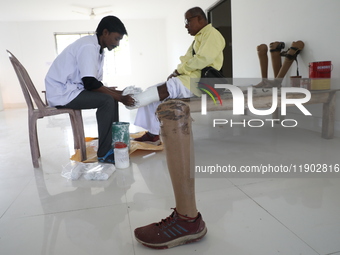 A worker covers a structure with plaster of Paris before manufacturing a prosthetic limb for Pappu Sarnakar, a forty-two-year-old three-whee...