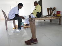 A worker covers a structure with plaster of Paris before manufacturing a prosthetic limb for Pappu Sarnakar, a forty-two-year-old three-whee...