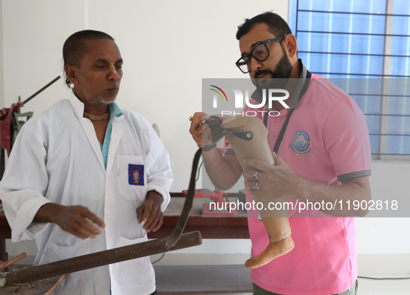 Workers examine a new prosthetic limb inside the Rehabilitation & Research Centre, a unit of Mahavir Seva Sadan, in Arambag on the outskirts...